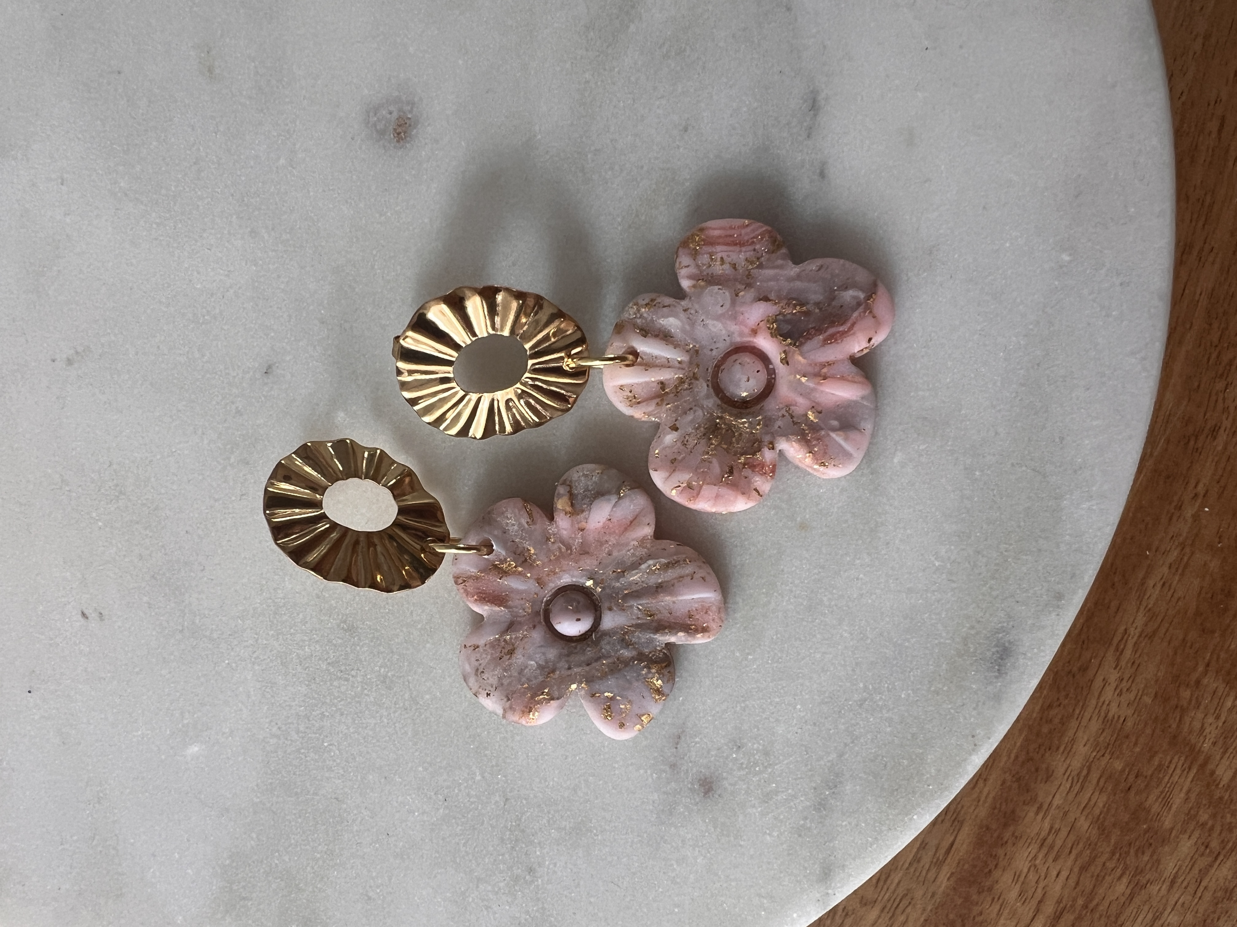 Gold sunburst and pink marble earring worn